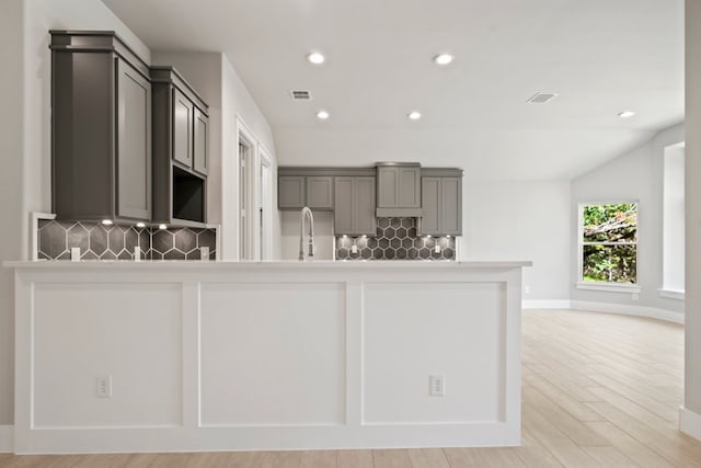 kitchen with visible vents, tasteful backsplash, light wood-style floors, and recessed lighting