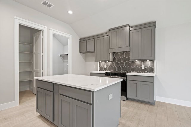 kitchen featuring electric stove, gray cabinets, tasteful backsplash, and visible vents