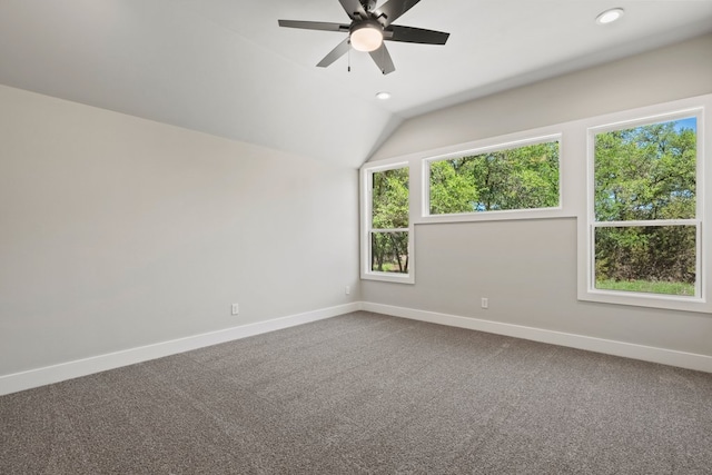spare room with a healthy amount of sunlight, dark carpet, and baseboards