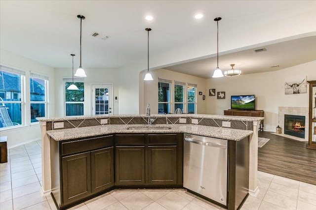 kitchen featuring a sink, light tile patterned floors, visible vents, dishwasher, and open floor plan