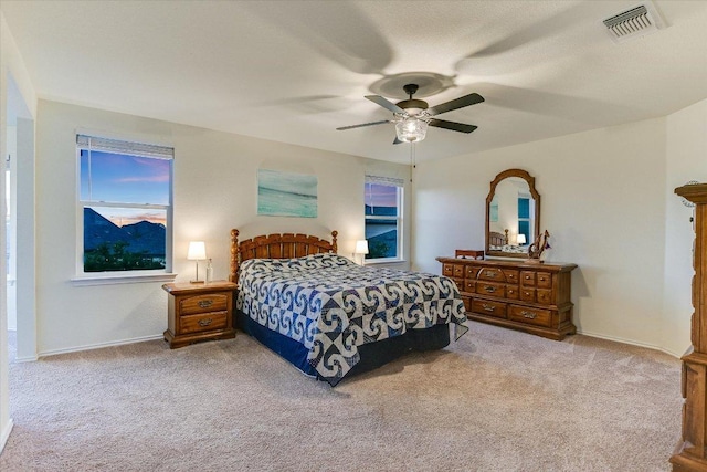 bedroom featuring visible vents, ceiling fan, light carpet, and baseboards