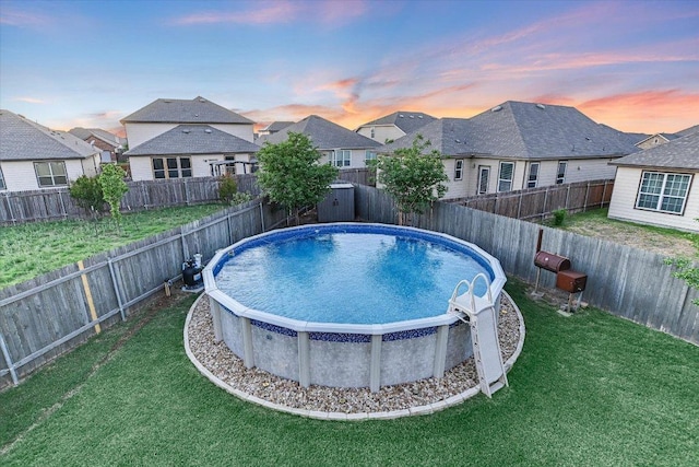 view of pool featuring a residential view, a yard, and a fenced in pool