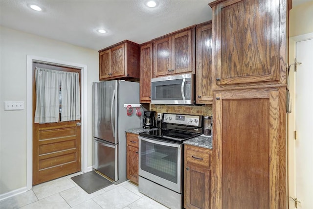 kitchen with tasteful backsplash, recessed lighting, appliances with stainless steel finishes, baseboards, and light tile patterned flooring
