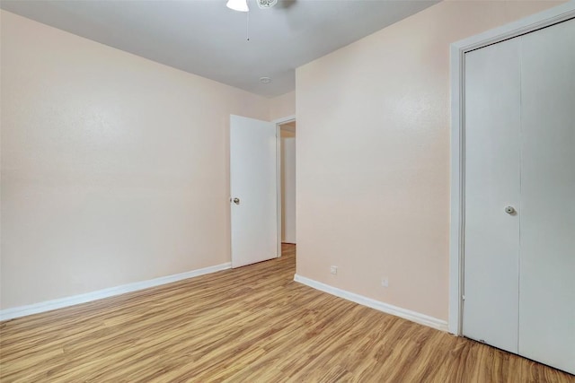 unfurnished bedroom featuring a closet, a ceiling fan, baseboards, and light wood-type flooring