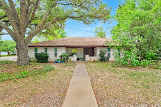 ranch-style house featuring brick siding