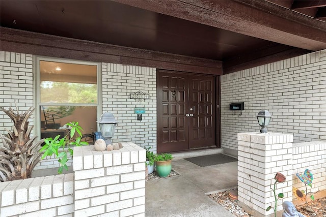 view of exterior entry featuring brick siding