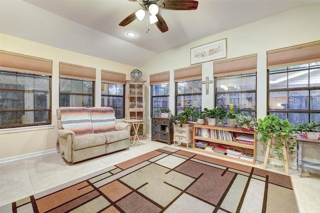 tiled living room featuring baseboards, ceiling fan, and lofted ceiling