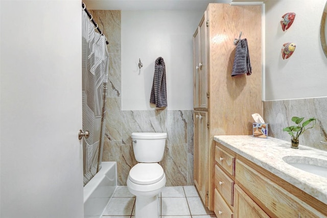 bathroom with tile walls, vanity, tile patterned floors, toilet, and shower / tub combo