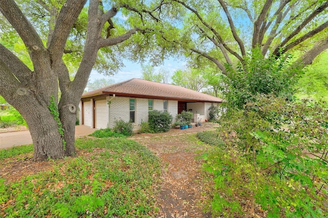 ranch-style home with concrete driveway, a garage, and brick siding