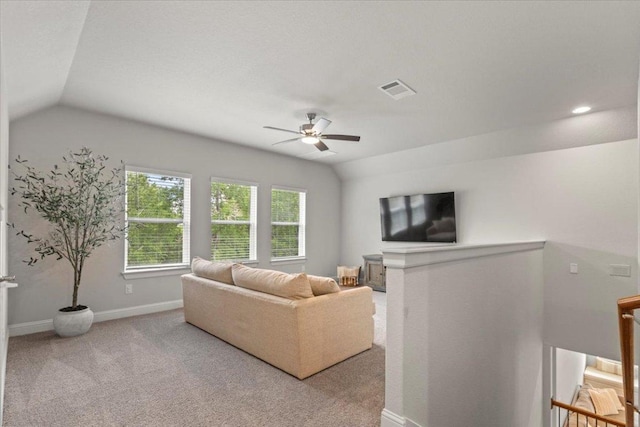 living room featuring ceiling fan, visible vents, vaulted ceiling, and carpet floors