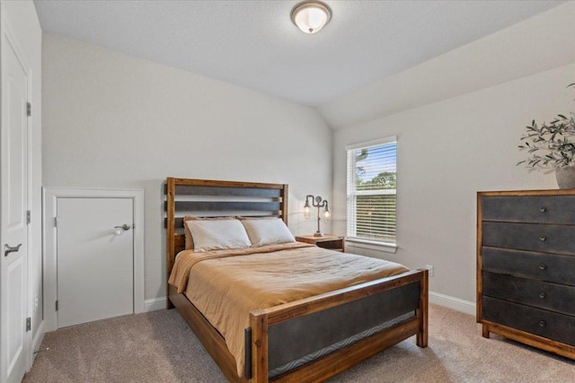 bedroom featuring lofted ceiling, light colored carpet, and baseboards