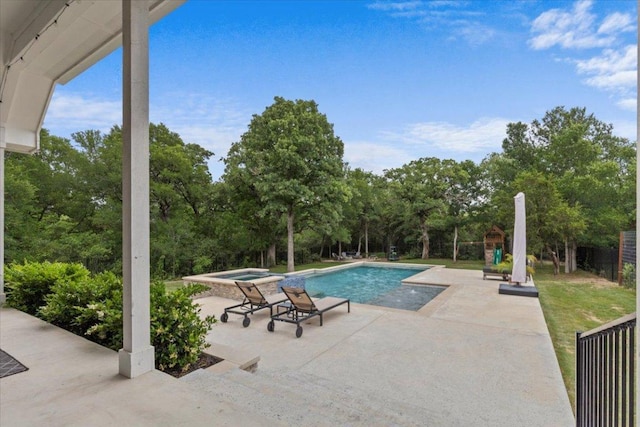 outdoor pool with fence, an in ground hot tub, and a patio area