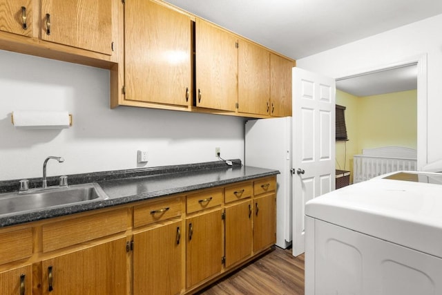 laundry area featuring washer / clothes dryer, wood finished floors, and a sink