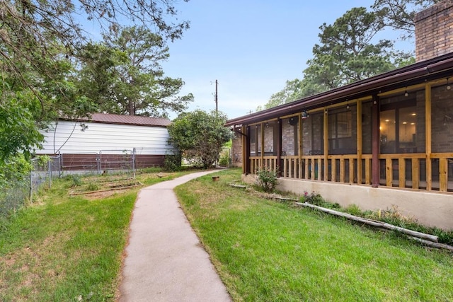 view of yard with a sunroom and fence