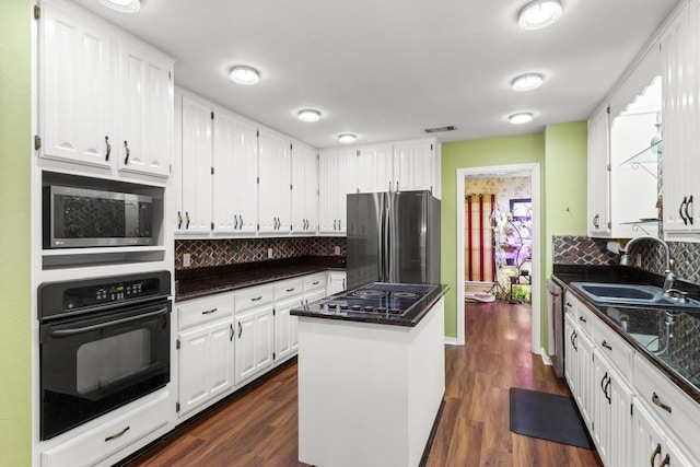 kitchen featuring black appliances, white cabinetry, a kitchen island, and a sink
