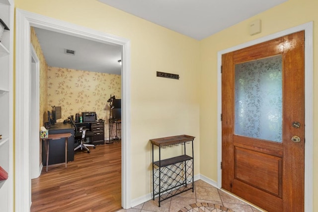 entrance foyer with visible vents, wood finished floors, and baseboards