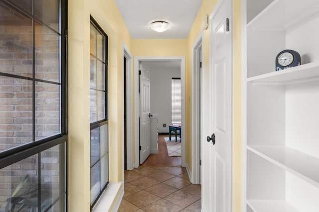 hall with tile patterned floors