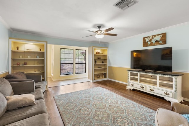 living area featuring crown molding, visible vents, baseboards, wood finished floors, and a ceiling fan