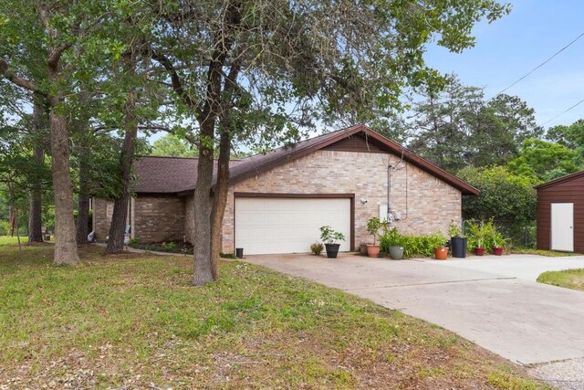 205 Kamakoa Ln, Bastrop, TX 78602 - view of front facade with concrete driveway, brick siding, a garage, and a front lawn