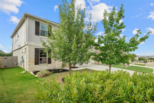 view of front of property with fence, a front yard, stucco siding, and stone siding