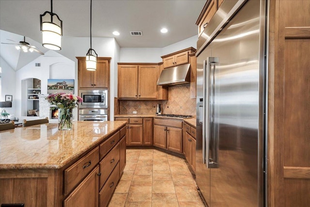 440 Currie Ranch Rd, Wimberley, TX 78676 - kitchen with tasteful backsplash, brown cabinetry, under cabinet range hood, built in appliances, and ceiling fan