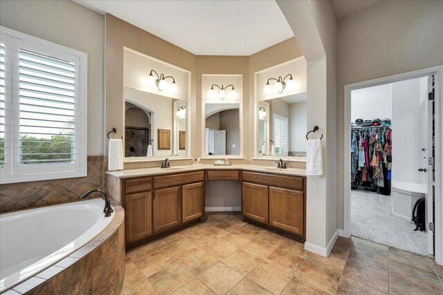 440 Currie Ranch Rd, Wimberley, TX 78676 - bathroom with a bath, a spacious closet, double vanity, and a sink
