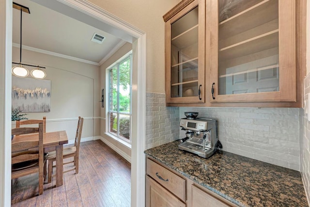 2402 Silent Brook Trl, Round Rock, TX 78665 - kitchen with crown molding, wood finished floors, glass insert cabinets, decorative backsplash, and dark stone counters
