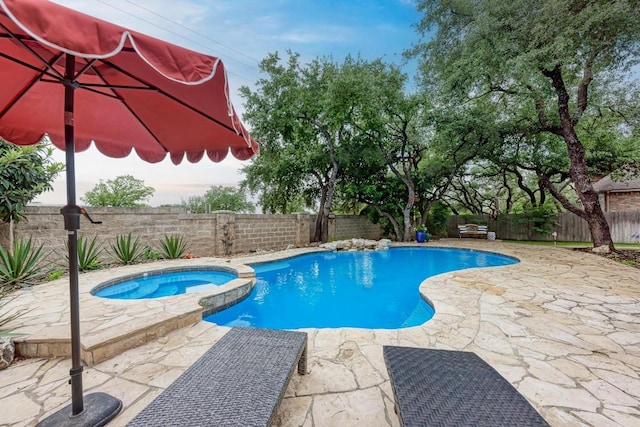 view of swimming pool featuring a patio, a fenced backyard, and a pool with connected hot tub