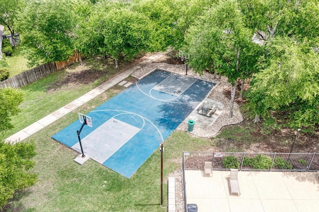 view of sport court with fence, basketball court, and a lawn