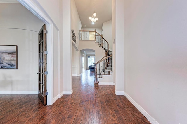 2402 Silent Brook Trl, Round Rock, TX 78665 - entrance foyer featuring arched walkways, dark wood-style floors, stairway, a chandelier, and a towering ceiling
