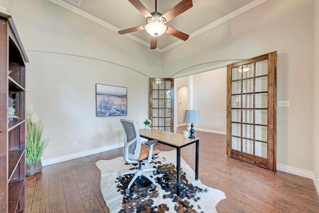 office featuring ceiling fan, baseboards, ornamental molding, arched walkways, and hardwood / wood-style floors