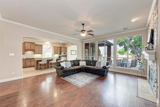 2402 Silent Brook Trl, Round Rock, TX 78665 - living area featuring arched walkways, light wood finished floors, ceiling fan, and ornamental molding
