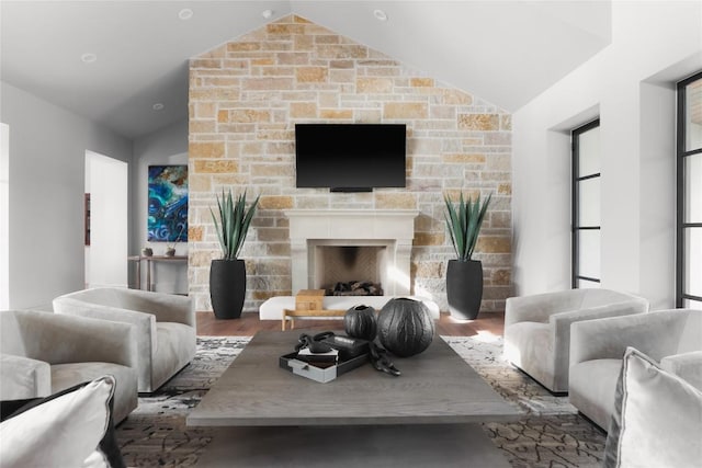 living area featuring wood finished floors, a fireplace, and vaulted ceiling