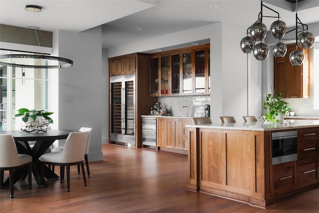 bar featuring bar area, beverage cooler, decorative backsplash, dishwashing machine, and dark wood-type flooring