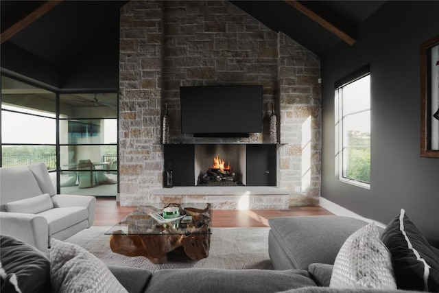 living room featuring a fireplace, wood finished floors, lofted ceiling with beams, and ceiling fan