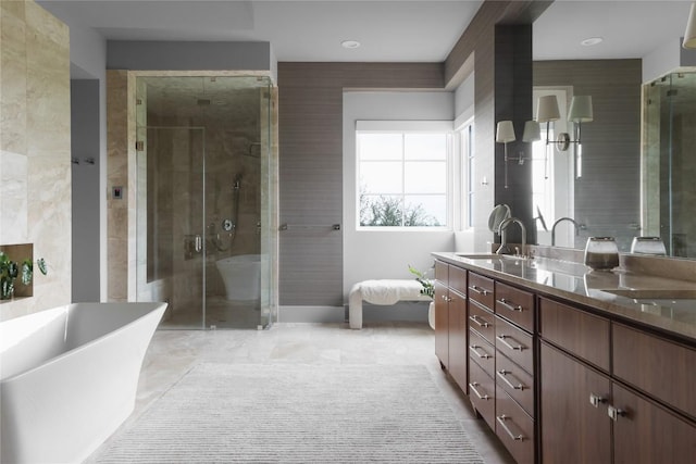 full bathroom featuring a soaking tub, a stall shower, double vanity, and a sink
