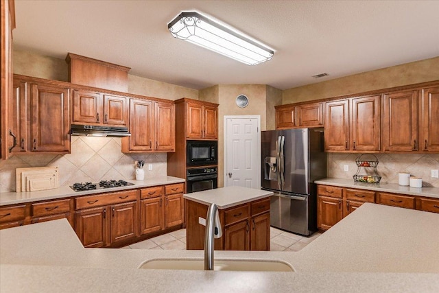 15617 Pumpkin Ridge Dr, Austin, TX 78717 - kitchen with black appliances, a sink, brown cabinets, and tasteful backsplash
