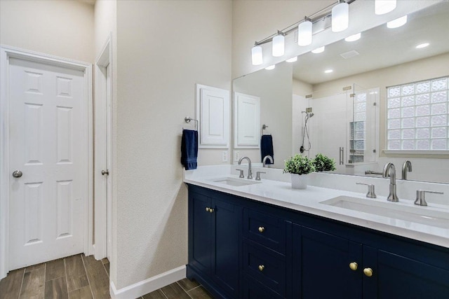 15617 Pumpkin Ridge Dr, Austin, TX 78717 - bathroom with wood finished floors, double vanity, a tile shower, and baseboards