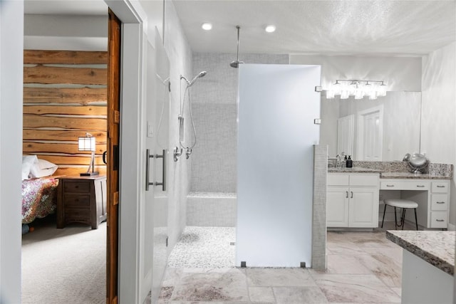ensuite bathroom featuring a walk in shower, vanity, and ensuite bathroom