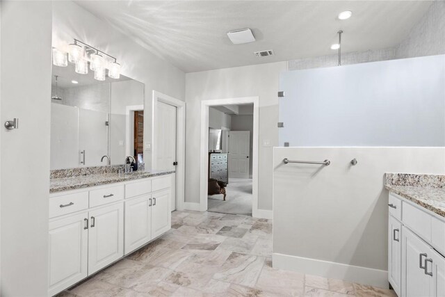 bathroom featuring walk in shower, visible vents, vanity, and baseboards