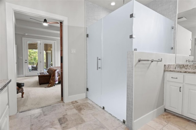 ensuite bathroom with vanity, a ceiling fan, ensuite bathroom, and baseboards