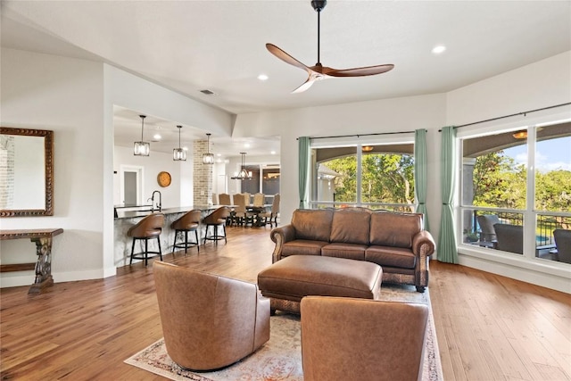 living room with a wealth of natural light, wood finished floors, a ceiling fan, and visible vents