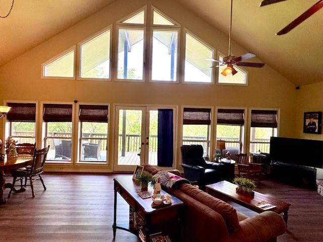 living room featuring wood finished floors, a ceiling fan, and high vaulted ceiling