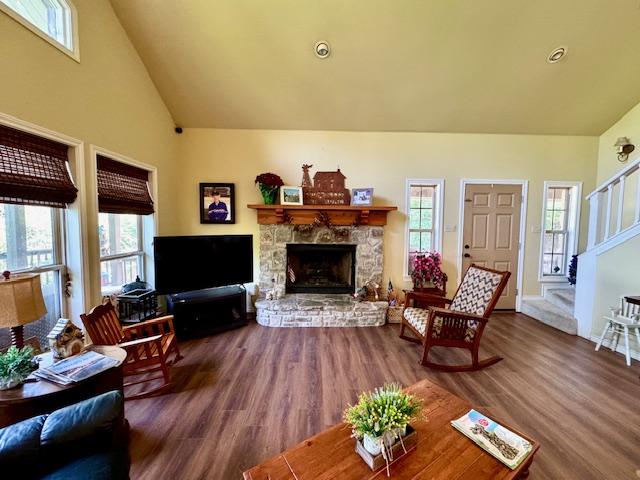 living area with a fireplace, a wealth of natural light, and wood finished floors