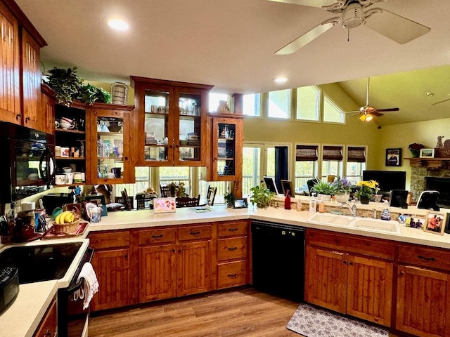 kitchen featuring range with electric cooktop, a sink, ceiling fan, light countertops, and black dishwasher