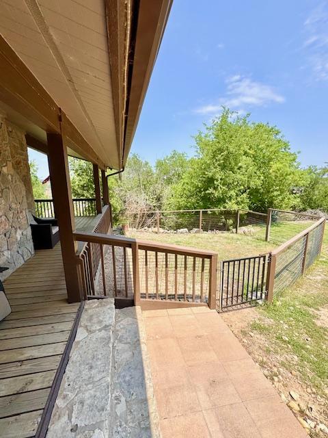 wooden deck featuring a lawn and a fenced backyard