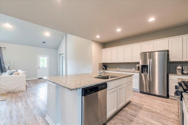 kitchen with stainless steel appliances, light wood-style flooring, open floor plan, and a sink