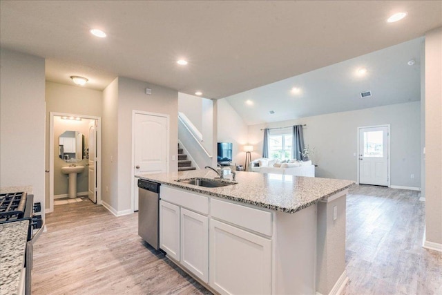 125 Groesbeck Ln, Leander, TX 78641 - kitchen featuring appliances with stainless steel finishes, a sink, open floor plan, light wood-type flooring, and white cabinets