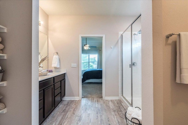 full bath featuring a shower stall, ensuite bath, vanity, and wood finished floors
