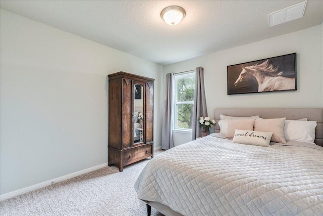 bedroom featuring baseboards, visible vents, and light colored carpet